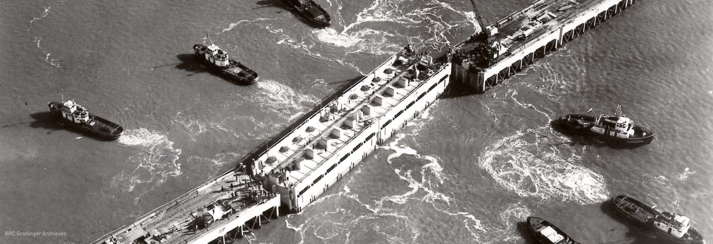 <p>Plaatsing van de laatste caisson voor de afsluiting van de Lauwerszee, 23 mei 1969. - Foto: KLM Aerocarto, collectie Groninger Archieven</p>
