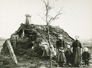 <p>Een moeder met drie kinderen voor hun plaggenhut bij Onstweddertange, ca. 1914. &ndash; Foto: Tonnis Post, collectie Groninger Archieven</p>
