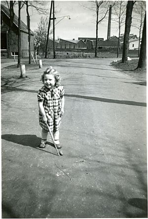 Meisje met tol, 1953, met op de achtergrond aardappelmeelfabriek 'De Twee Provinciën'. - Foto: Streekhistorisch Centrum Stadskanaal (18311)