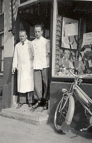 Jan Korma en een bediende in de deuropening. - Foto: 100 jaar Tuinwijk