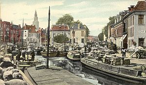 <p>Aan het Winschoterdiep laden en lossen schepen hun lading, ca. 1920. &ndash; Ansicht: Collectie Groninger Archieven</p>
