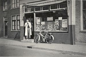 Kapper Korma in de deuropening van zijn zaak aan de Moesstraat. - Foto: 100 jaar Tuinwijk