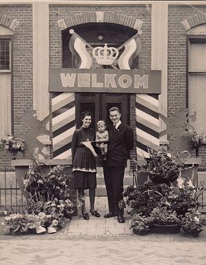 <p>Ds. Krijger na zijn terugkeer met zijn vrouw Alida met de kleine Dick voor de pastorie in Oostwold. &ndash; Foto: Archief Peter Akkerman</p>

