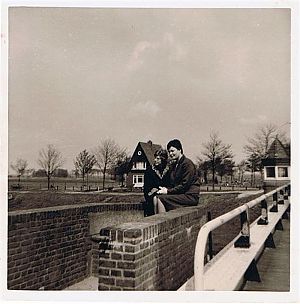Mijn vriendin en ik zitten op een bankje bij de Aduarderbrug, de brug waar ze afsprongen. Netjes in het pak, zelfs met handschoentjes aan, want dat was toen mode. Op de achtergrond het huis van de brugwachter. - Foto: familie Duisterwinkel