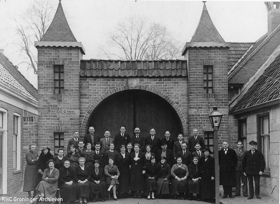 bewoners poseren voor nagebouwde poort van het Augustijner klooster op 1 juli 1937 - www.beeldbankgroningen.nl [818-0527]