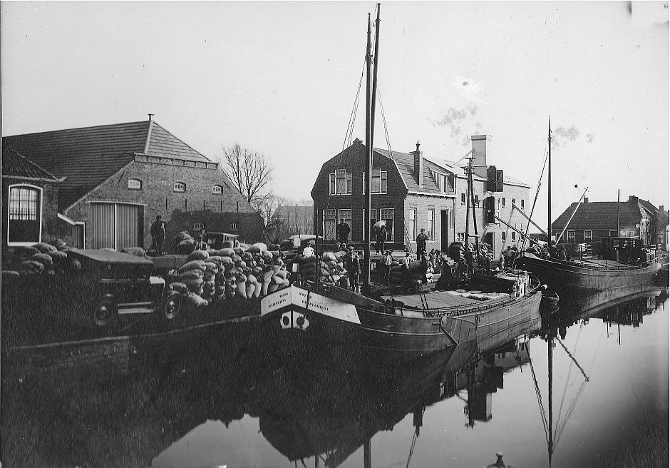 <p>Een bolschip meert af bij een van de drie graanpakhuizen in de haven van Nieuwolda. - Foto: Nieuwolda in oude ansichten, Europese Bibliotheek</p>