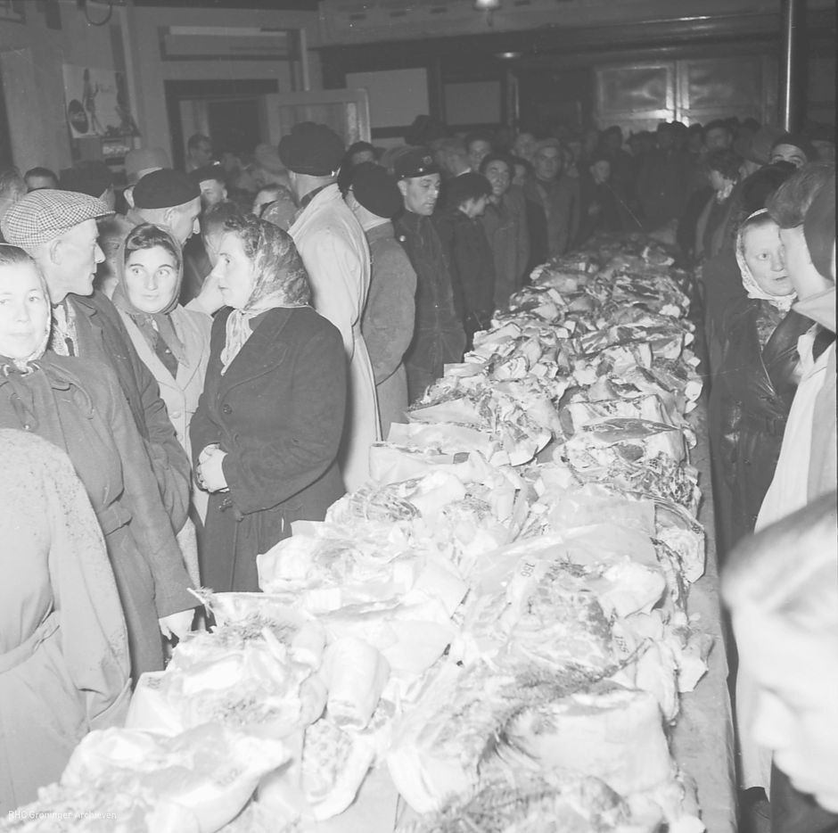 <p>Vleesuitdeling bij de spekclub van Warffum in het dorpscaf&eacute;, 1956. - Foto: Fotobedrijf Piet Boonstra, www.beeldbankgroningen.nl (2248-029146)</p>
