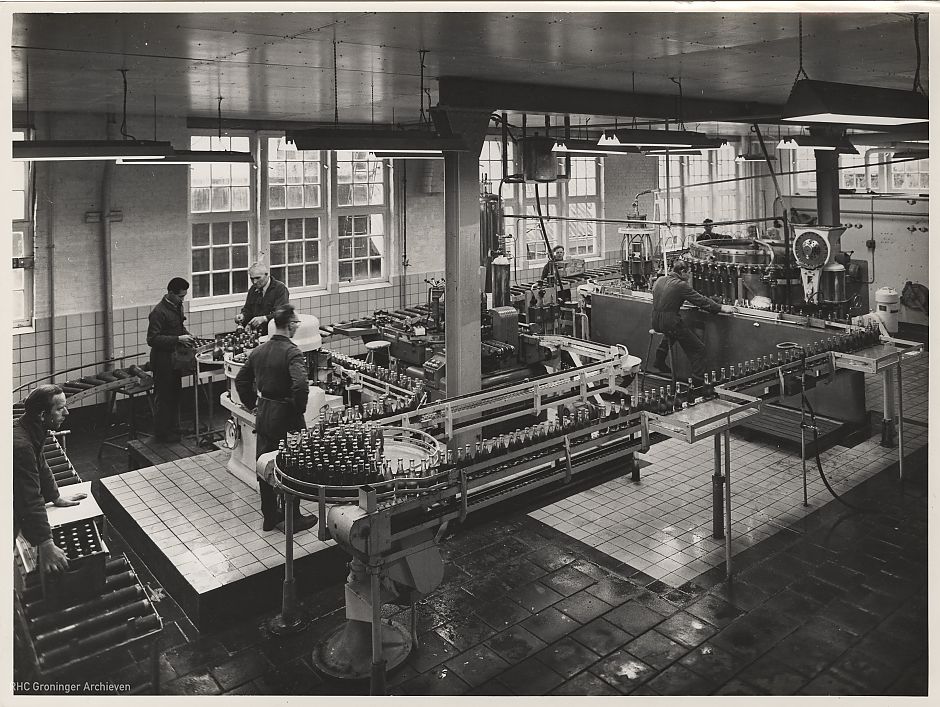 Binnen in de fabriek: enkele werknemers bij de Ranja-Soda-kolonne in 1957 - Foto: Fotobedrijf Piet Boonstra, www.beeldbankgroningen.nl (2138-7034)