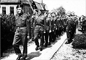 Canadese soldaten marcheren op 11 mei 1945 naar de hervormde kerk in Wagenborgen waar een herdenkingsdienst voor hun 23 gesneuvelde makkers wordt gehouden.