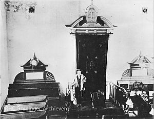 <p>Het interieur van de synagoge, met een onbekende voorzanger in het midden. De datering van de opname is niet bekend. &ndash; Foto: collectie Groninger Archieven</p>
