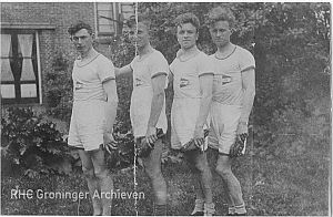 <p>Vier leden van de estafetteploeg van atletiekvereniging &#39;Clias&#39;&nbsp;poseren in sporttenue met de spikes in de hand. - Foto: maker onbekend, Groninger Archieven</p>
