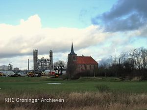 Het kerkje van Heveskes, met op de achtergrond de chemische industrie.