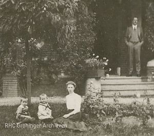 <p>Johan Huizinga staand op het bordes, zijn vrouw en kinderen zittend in het gras. - Foto: Collectie Groninger Archieven</p>
