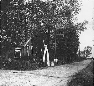 Beneden Verlaat, Veendam. Voor het tuinpad twee walviskaken, vroeger door zeelui meegenomen. Hier kregen we af en toe wat melk en veldproducten, ’40-’45. Tegenwoordig staan de kaken in het Veenkoloniaal Museum.