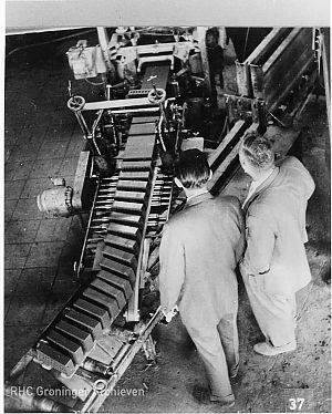 Twee mannen naast een afsnijdautomaat in steenfabriek Boerdam, bij Middelstum. - Foto: www.beeldbankgroningen.nl (818-19364)